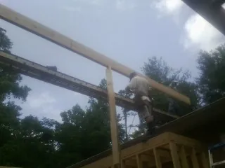 Carpenter setting a ridge beam over a new addition frame — Ice Dam Removal by Roofing Brothers in Piedmont